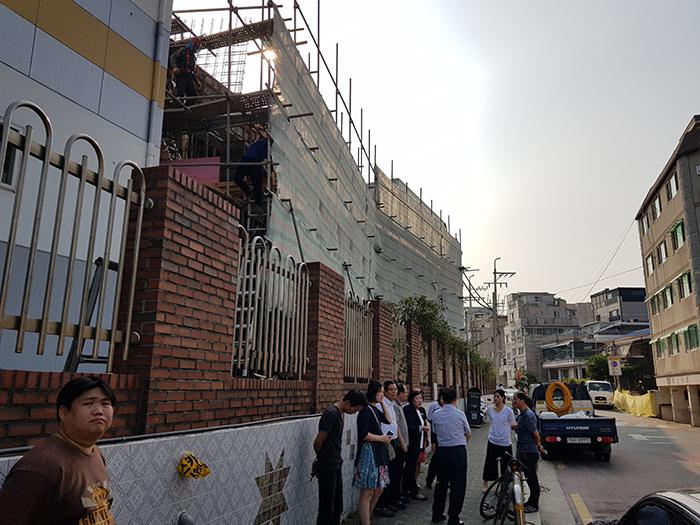사진 왼쪽이 은석초등학교 공사현장 가림막 아래서 신복자 구의원과 구청관계자들이 민원인들 이야기를 듣고 있다사진 동대문 이슈
