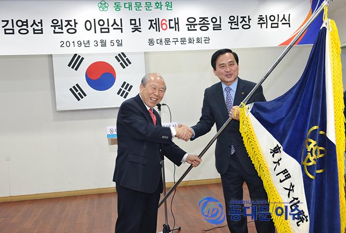 김영섭 전 문화원장왼쪽이 윤종일 신임 문화원장에게 문화원기를 인계하고 있다사진  동대문 이슈 