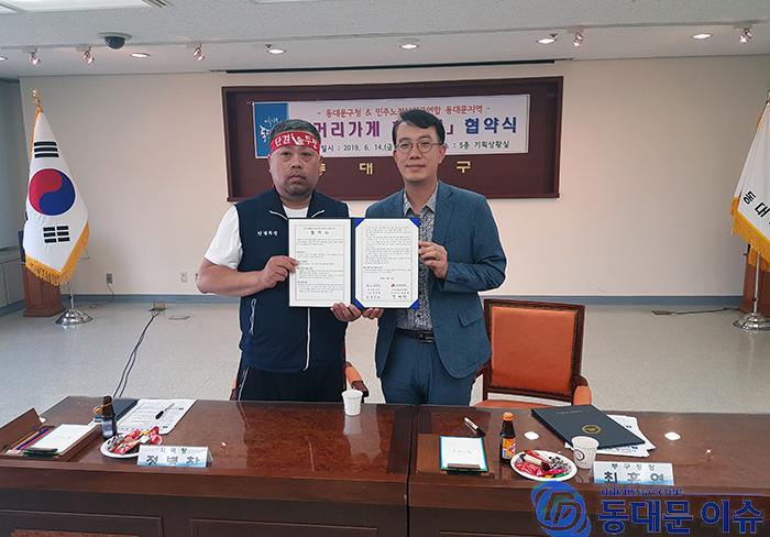 동대문구 최홍연 부구청장과 정병찬 민노연 동대문 중랑지역연합회 지역장이 협약서를 보여주고 있다